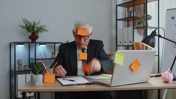 Tired exhausted senior business man office manager with laptop sticky notes sticks with many tasks video