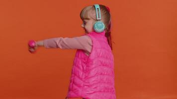 Cheerful attractive girl listening music via headphones and dancing disco fooling around having fun video
