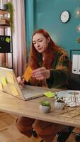 Tired businesswoman using laptop sticky notes with many tasks overworked checking time on clock video