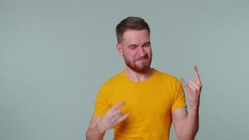 Overjoyed happy man showing rock n roll gesture by hands, cool sign, shouting yeah with crazy face video