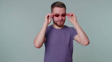 Playful happy man wearing sunglasses blinking eye looking at camera with smile, winking, flirting video