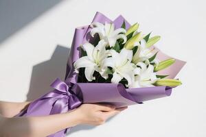 Hands holding a wrapped bouquet of lily photo