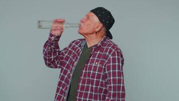 Drunk man after party drinks vodka from bottle, celebrating victory win, alcohol addiction problem video