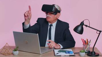 Senior businessman using headset helmet app to play simulation game, watching virtual reality video