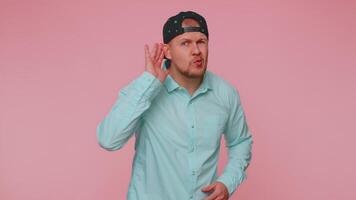 Man trying hear you, looking confused and frowning, keeping arm near ear for louder voice, repeat video
