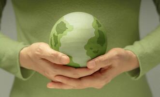 Green earth held gently in hands, symbolizing environmental conservation, care for the planet, and sustainability photo