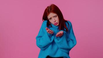 Redhead cute woman in sweater showing a little bit gesture with sceptic smile, showing minimum sign video