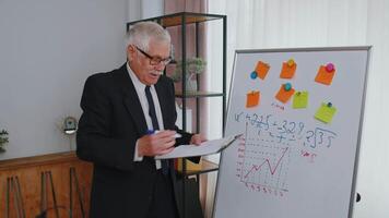 Senior business man coach leader conference speaker explain project strategy on office whiteboard video