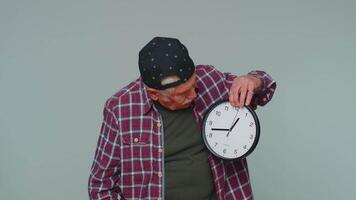 Confused senior man with anxiety checking time on clock running late to work being in delay deadline video