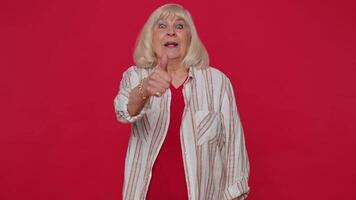 Senior stylish old woman in shirt showing thumbs up and nodding in approval, successful good work video