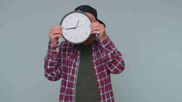 Senior man holding clock watch, hiding, checking time on clock, running late to work being in delay video