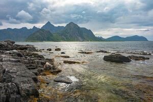 Rocky mountain view from opposite shore with rocks, Lofoten Norway photo