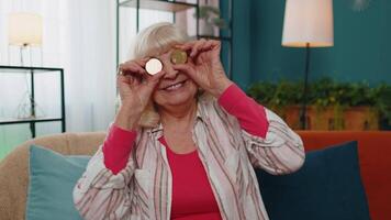 Senior old grandmother showing golden bitcoins, cryptocurrency investment, mining, future technology video