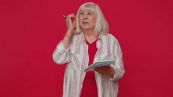 Thoughtful journalist woman making notes, writing down thoughts with pen into notepad notebook diary video