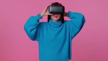 Girl using virtual reality futuristic technology VR headset helmet to play simulation 3D game video