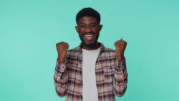 African american man shouting, raising fists in gesture I did it, celebrating success, winning video