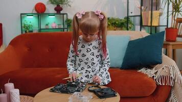 Little girl kid fixing repairing computer mainboard technology part, using magnifying glass at home video