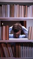 A man is looking at books on a shelf video