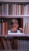 A man is looking at a book shelf video