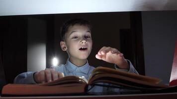 A boy reading a book in the dark video