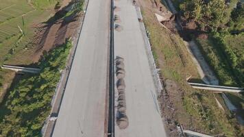 Aerial View of Construction Progress on a Rural Road Surrounded by Lush Greenery and Natural Landscapes video