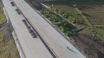 Aerial View of a Developing Infrastructure Project with Freshly Paved Road and Surrounding Greenery video