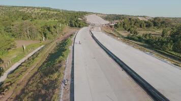 Aerial View of Construction Progress on a Newly Built Road Surrounded by Lush Green Landscapes video