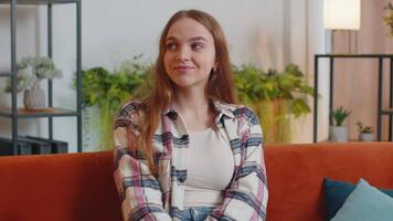 Young woman presses index finger to lips makes silence gesture sign do not tells secret at home video