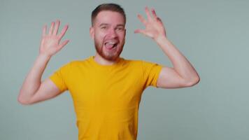 Funny joyful man making playful silly facial expressions, grimacing, fooling around showing tongue video