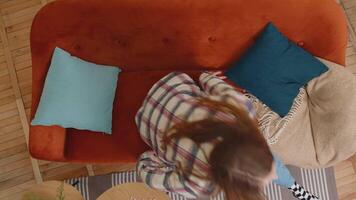 Top view of smiling relaxed teen girl rest lying on comfortable sofa, feel stress free sleeping video