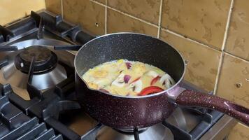 A pot of eggs and vegetables simmers on a stove, highlighting home cooking, breakfast, and culinary skills, with a focus on sauteing video