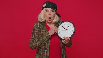 Confused senior woman with anxiety checking time on clock running late to work, being delay deadline video