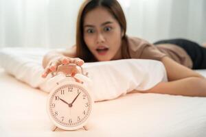 Stress young woman show clock alarm, lady is late appointment or work or class study, overslept, difficulty get up in mornings, time worried, not on time, sleepy, over due, Hurry up time photo