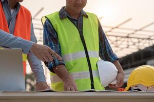 inspector or engineer inspecting construction and quality assurance new house using a blue print. Engineer or architects or contactor work to build the house before handing it over to the homeowner photo