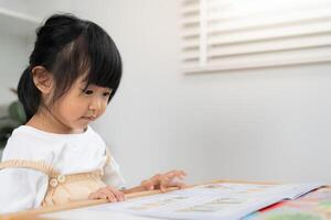 enjoy Asian children relax read book at home. daughter and reading a story. learn development, childcare, laughing, education, storytelling, practice, imagine, reduce addiction mobile phone photo
