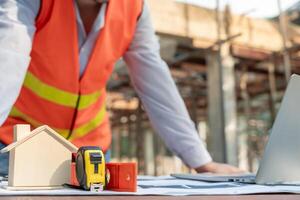 inspector or engineer is inspect construction and quality assurance new house using a blue print. Engineer or architects or contactor work to build the house before handing it over to the homeowner photo