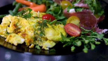 omelette and salad plate of food with a yellow omelet and a green leafy vegetable. The plate is white and the food is arranged neatly video