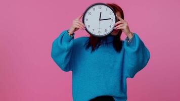 Young woman holding clock watch, hiding, checking time on clock, running late to work being in delay. video