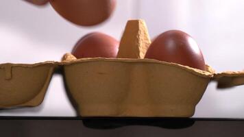 4K macro footage of man taking three eggs from yellow cardboard package side view video