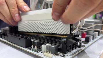 Hands disassemble the device with the motherboard in the electronics repair laboratory using tools and components for troubleshooting and maintenance video