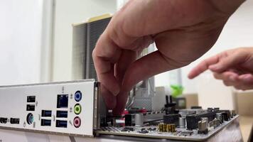 A technician disassembles the motherboard in an electronics repair lab using tools and components for troubleshooting and maintenance. video