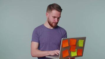 Exhausted man freelancer with pasted sticker notes use laptop computer, concentration problem. video