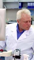 Thoughtful male scientist in a modern lab, immersed in research video