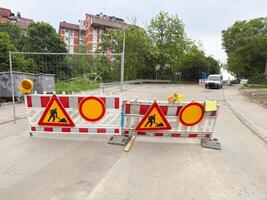 Street closed with multiple construction signs and warning barriers. Temporary roadblock signals active maintenance work. photo