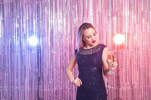 Party, drinks, holidays and celebration concept. Smiling woman in evening dress with glass of sparkling wine over shiny photo