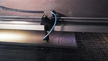 Laser cutting machine engraving foam material. Close-up of an industrial laser cutter precisely engraving shapes into a sheet of foam. video