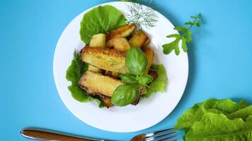 Zucchini with a crispy crust and fresh salad on a blue background video