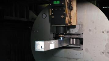 Laser cutting machine working on metal profile. Industrial laser cutter precisely processes a rectangular aluminum tube, creating holes and cutouts. video