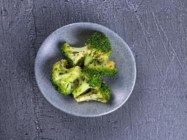 plate a bowl of broccoli on a gray table photo