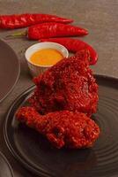 a plate of food with a bowl of sauce and a plate of chili peppers photo